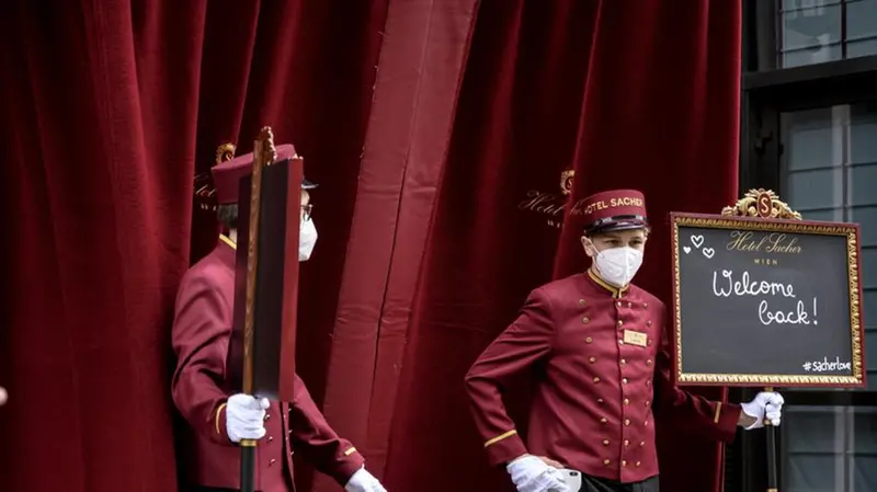 Due camerieri dell'Hotel Sacher di Vienna indossano la mascherina - © Foto EPA/Christian Bruna