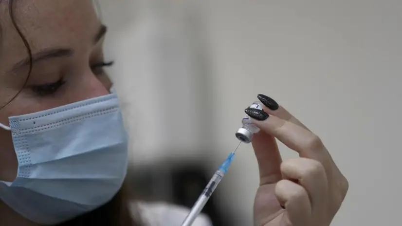 Un'infermiera prepara una dose di vaccino da somministrare - Foto Epa © www.giornaledibrescia.it