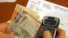 Calcolatrice, bollette e denaro - Foto © www.giornaledibrescia.it