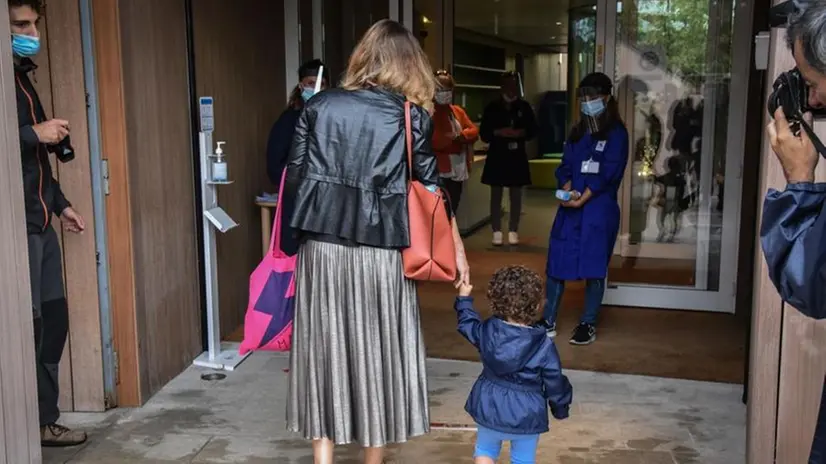 Una mamma con la figlia all'ingresso di un asilo nido - Foto Epa / Ansa © www.giornaledibrescia.it