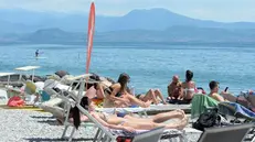 Turisti in spiaggia al lago di Garda - Foto Marco Ortogni/Neg © www.giornaledibrescia.it