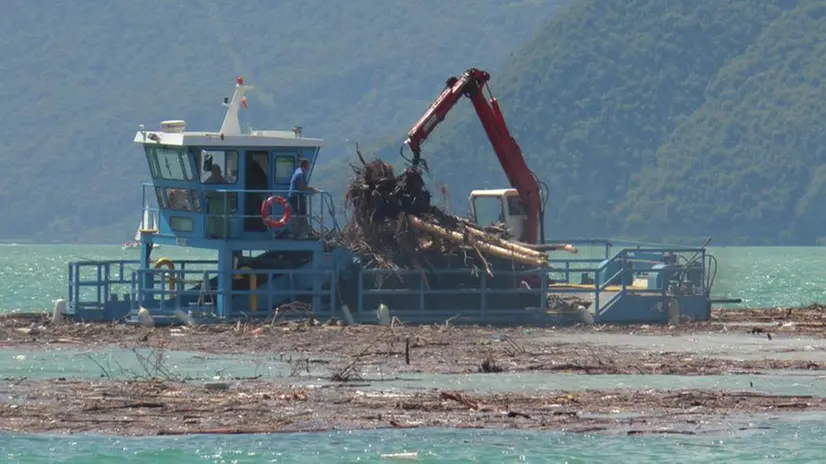 Il battello spazzino all'opera per togliere alghe e detriti dal lago d'Iseo