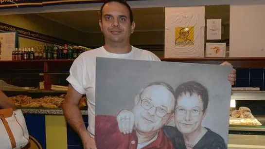 Il figlio Marco con il ritratto di Frank e Vanna - Foto © www.giornaledibrescia.it