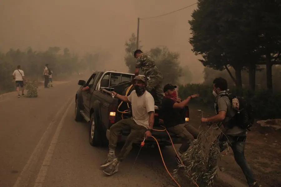 I residenti di Evia combattono le fiamme nel bosco vicino al villaggio