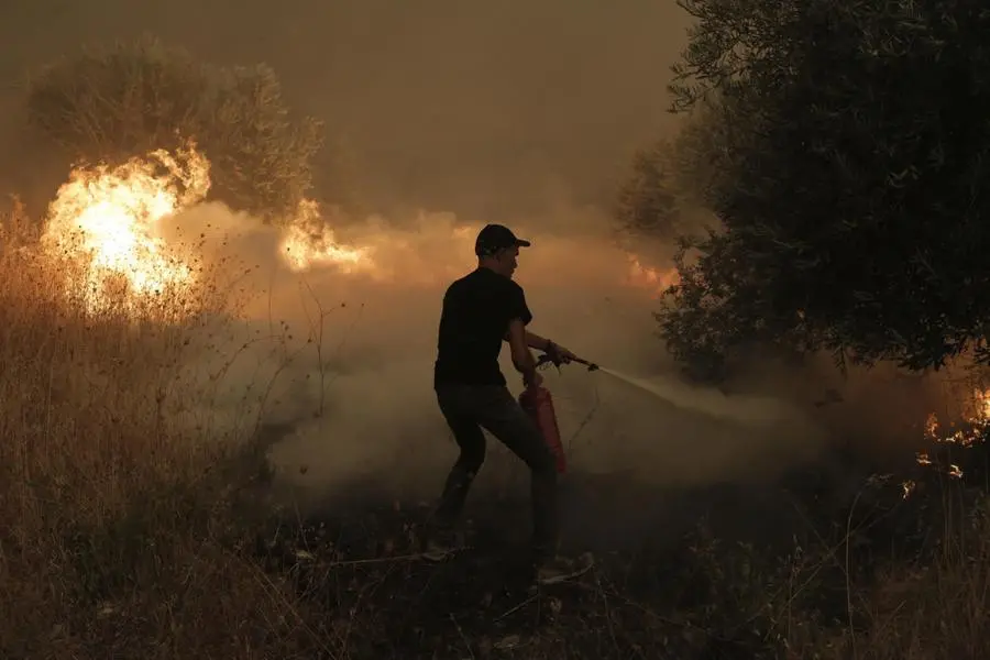 I residenti di Evia combattono le fiamme nel bosco vicino al villaggio