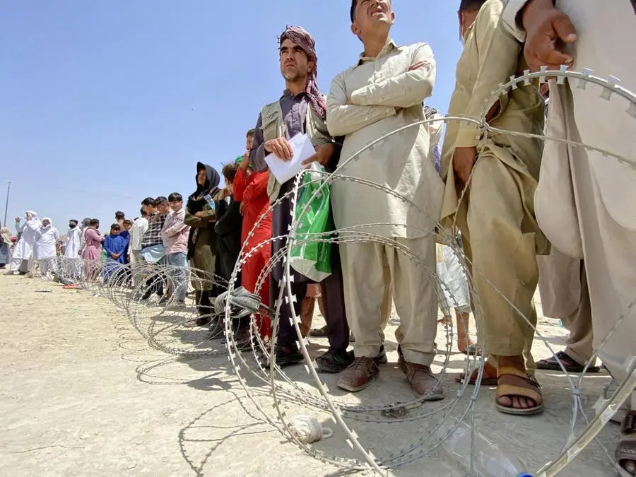 Persone ammassate dietro il filo spinato all'aeroporto di Kabul