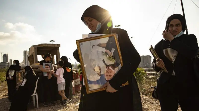Una donna stringe la foto di un familiare - Foto © Francesca Volpi / WeWorld