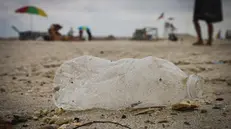 Una bottiglietta di plastica sulla spiaggia