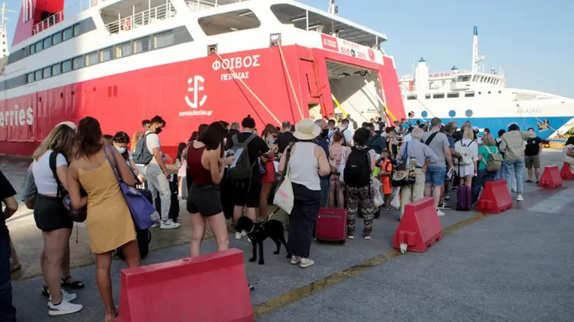 Passeggeri che stanno per salire su un traghetto al Pireo - Foto Ansa  © www.giornaledibrescia.it