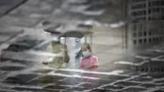 Mamma e figlia si proteggono dalla pioggia