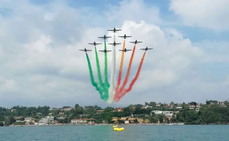 L'alone tricolore della Pattuglia Acrobatica Nazionale sullo specchio d'acqua di Porto Dusano - © www.giornaledibrescia.it