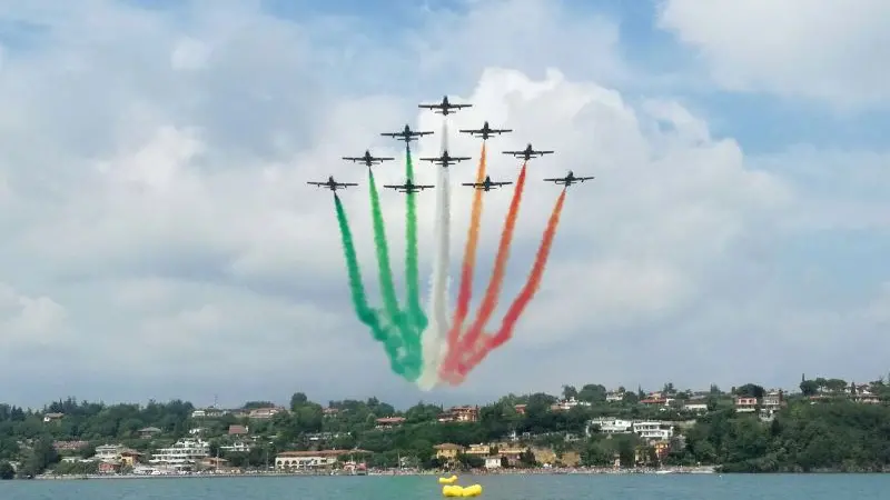 L'alone tricolore della Pattuglia Acrobatica Nazionale sullo specchio d'acqua di Porto Dusano - © www.giornaledibrescia.it