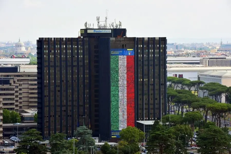 La maxi bandiera di Poste issata sulla sede centrale di Roma