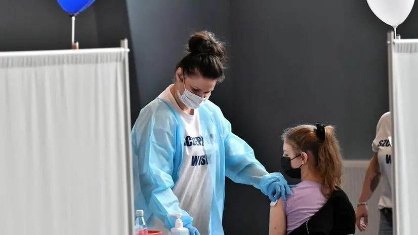 Una donna con meno di 60 anni riceve una dose di vaccino - Foto Ansa/Maciej Kulczynski © www.giornaledibrescia.it