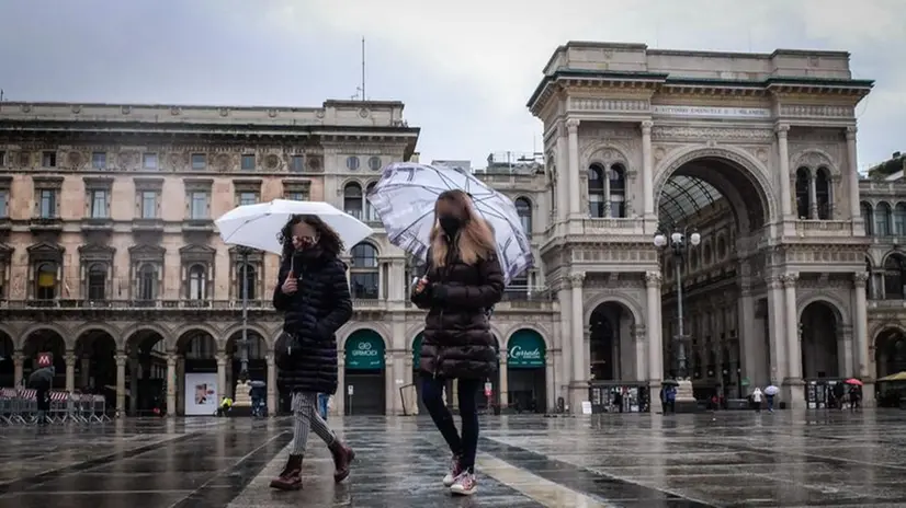 A Milano sotto la pioggia con la mascherina - Foto Ansa/Matteo Corner © www.giornaledibrescia.it