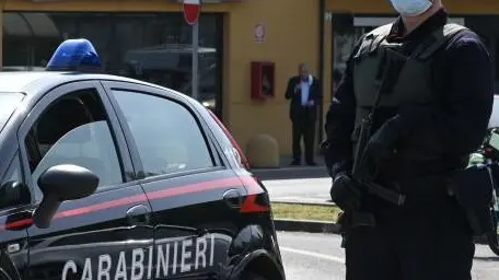 Un carabiniere accanto all'auto di pattuglia - © www.giornaledibrescia.it