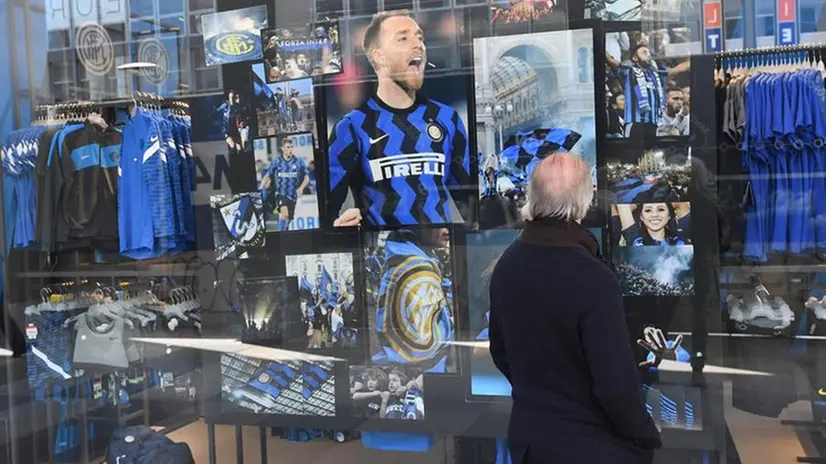 Un tifoso guarda la vetrina dell'Inter store a Milano - Foto Ansa/Daniel Del Zennaro © www.giornaledibrescia.it