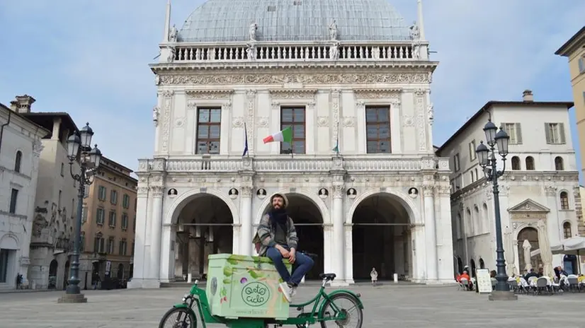 Andrea Morandi di Ortociclo in piazza Loggia con una delle sue cargobike - Foto pagina Facebook di Ortociclo