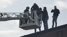 Gli agenti durante il fermo del ladro sul tetto - © www.giornaledibrescia.it
