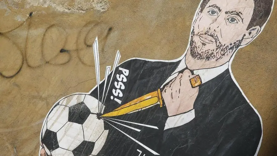L'artista Laika_mcmliv ha ritratto Andrea Agnelli, tra i promotori della Superlega, mentre buca un pallone da calcio - Roma - Foto Ansa © www.giornaledibrescia.it