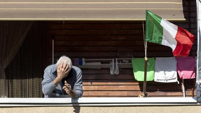 Un uomo al balcone durante il lockdown - Foto Ansa/Massimo Percossi © www.giornaledibrescia.it