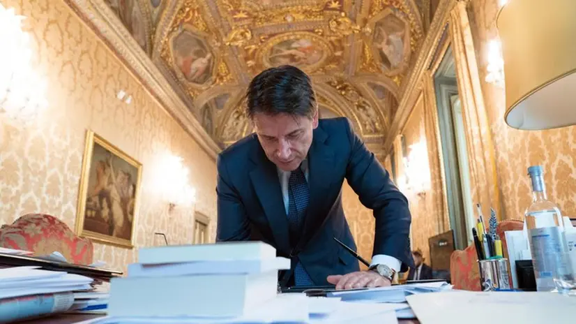 Giuseppe Conte mentre firma uno dei 19 Dpcm sul fronte Covid - Foto Ansa © www.giornaledibrescia.it