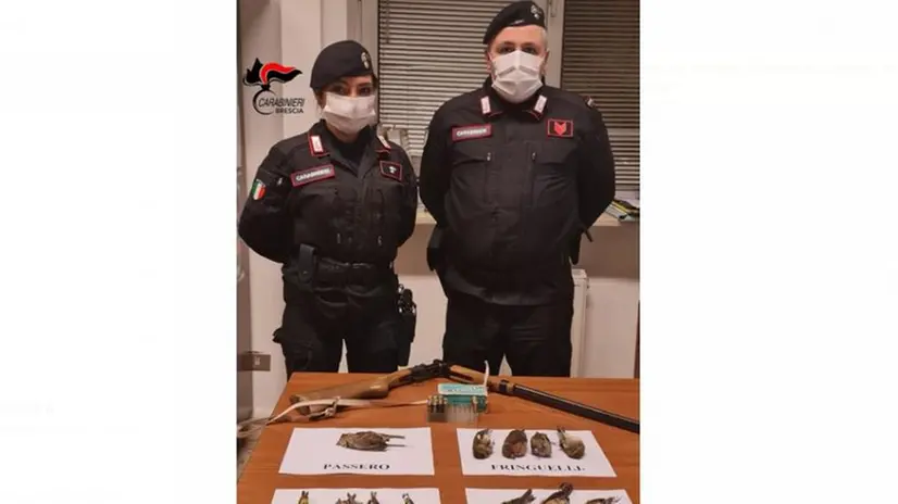 I carabinieri di Verolanuova con il fucile e gli uccellini sequestrati - Foto © www.giornaledibrescia.it