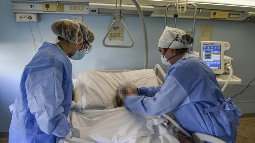 Medici assistono un paziente affetto da coronavirus - Foto Ansa © www.giornaledibrescia.it