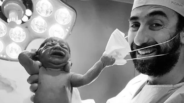 Un neonato che cerca di strappare la mascherina al medico: la foto, pubblicata da un ginecologo di Dubai, è uno dei simboli del 2020 - Foto da Instagram/Samer Cheaib