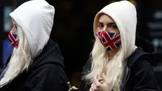 Due ragazze indossano mascherine con la Union Jack