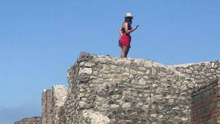 La turista sul tetto delle Terme antiche di Pompei - Foto Facebook Antonio Irlando