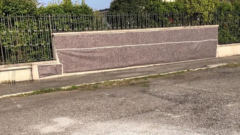 I teli che sono stati posizionati per coprire le scritte sui muri del cimitero di Cellatica - Foto © www.giornaledibrescia.it