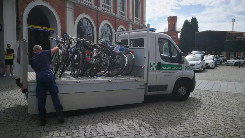 Le operazioni di rimozione delle bici da pali e fioriere - Foto © www.giornaledibrescia.it