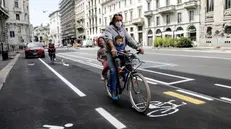 Padre e figli in bicicletta - Foto Ansa/Mourad Balti Touati © www.giornaledibrescia.it