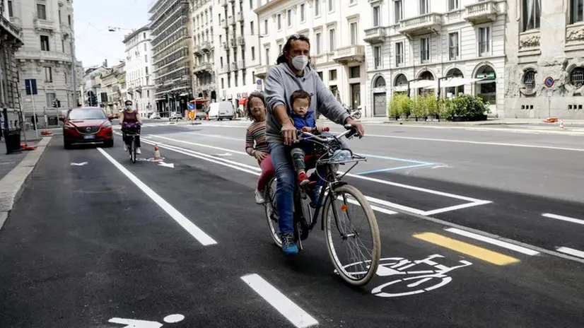 Padre e figli in bicicletta - Foto Ansa/Mourad Balti Touati © www.giornaledibrescia.it