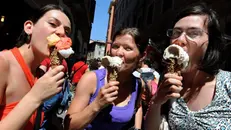 Ragazze mangiano un gelato durante una passeggiata - Foto Ansa/Claudio Onorati