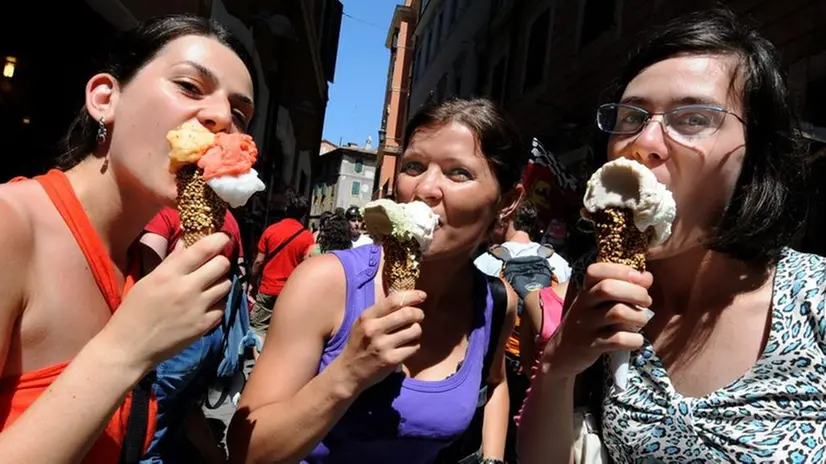 Ragazze mangiano un gelato durante una passeggiata - Foto Ansa/Claudio Onorati