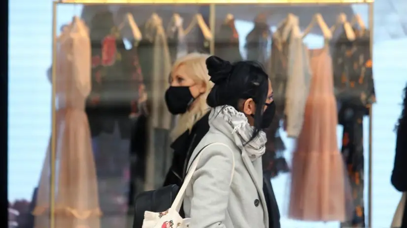 Due donne davanti ad un negozio passeggiano indossando la mascherina - Foto Ansa © www.giornaledibrescia.it