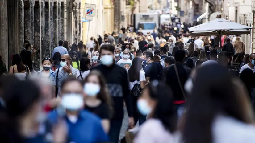 Passanti in strada indossano la mascherina per evitare il contagio da coronavirus - Foto Ansa/Massimo Percossi