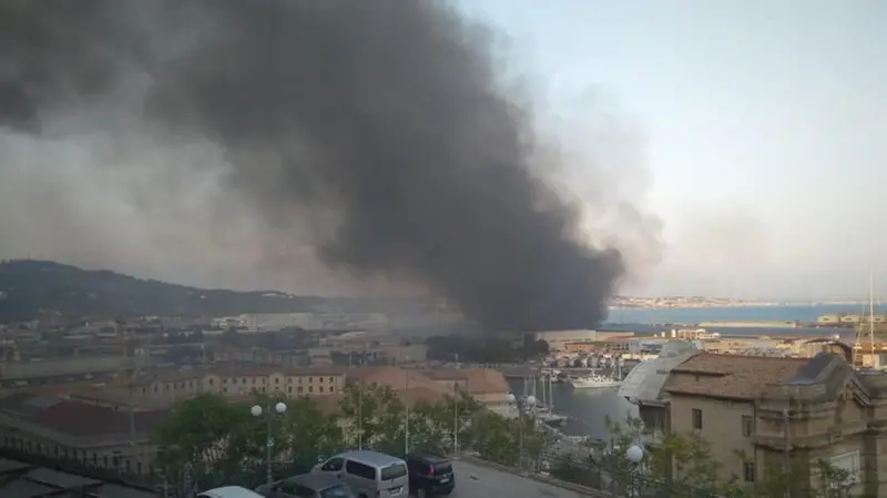 Ancona, il fumo che si leva dal porto visibile in lontananza - Foto © www.giornaledibrescia.it
