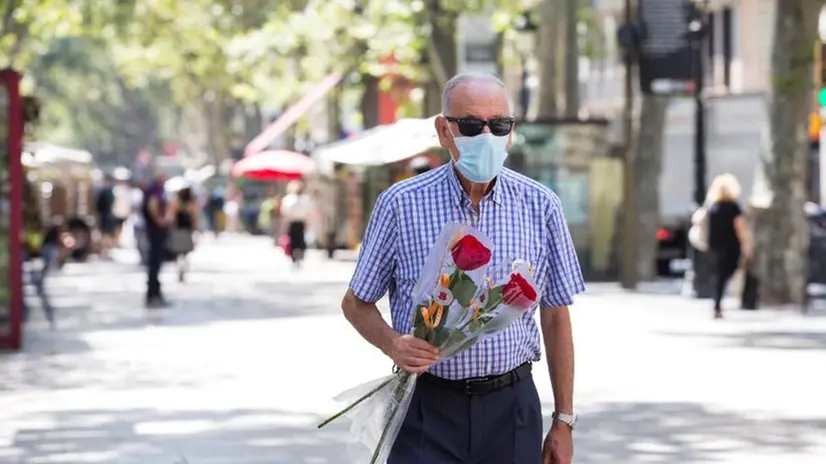 Un uomo passeggia in strada indossando la mascherina - Foto Epa/Quique Garcia