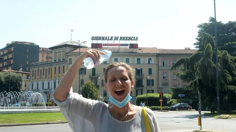 Una ragazza si rinfresca dall'afa in piazza della Repubblica a Brescia - Foto Marco Ortogni/Neg © www.giornaledibrescia.it