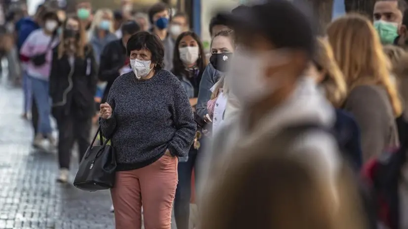 Gente con la mascherina protettiva - Foto Ansa  © www.giornaledibrescia.it