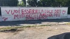 La scritta comparsa nei giorni scorsi sul muro del cimitero a Cellatica - © www.giornaledibrescia.it