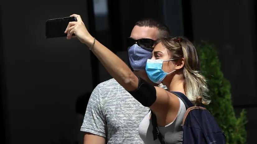 Una coppia si scatta un selfie indossando la mascherina - Foto Epa/Robert Ghement