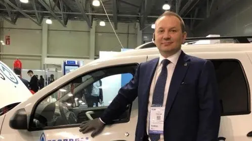 Un manager russo davanti alla Lada Largus in fiera a Mosca