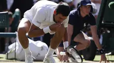 Novak Djokovic accasciato sull'erba di Wimbledon