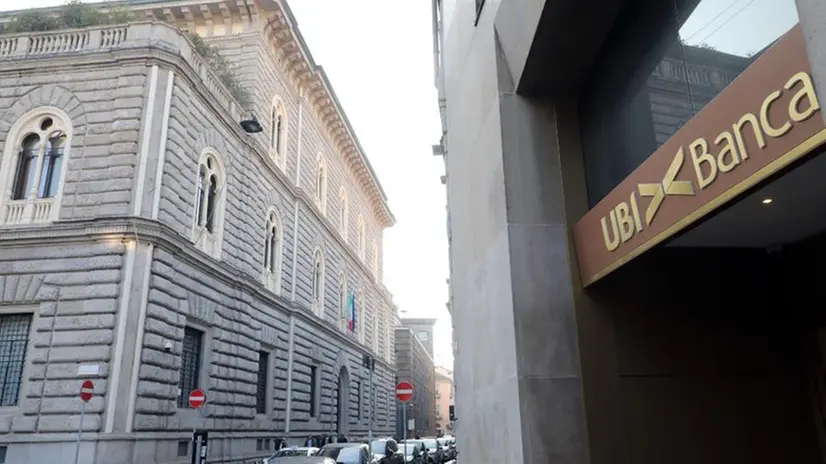 Un'insegna Ubi Banca e sullo sfondo palazzo Ca' de Sass a Milano - Foto Ansa/Matteo Bazzi