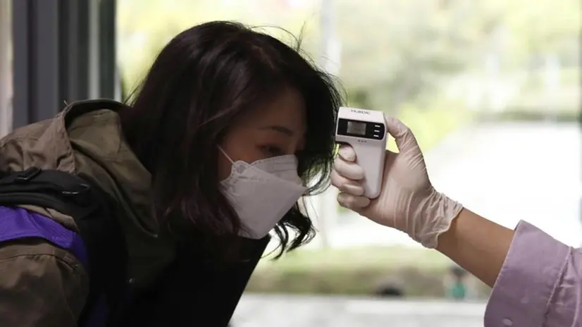 Una donna viene sottoposta al controllo della temperatura corporea - Foto Ansa/Epa/Jeon Heon-Kyun © www.giornaledibrescia.it