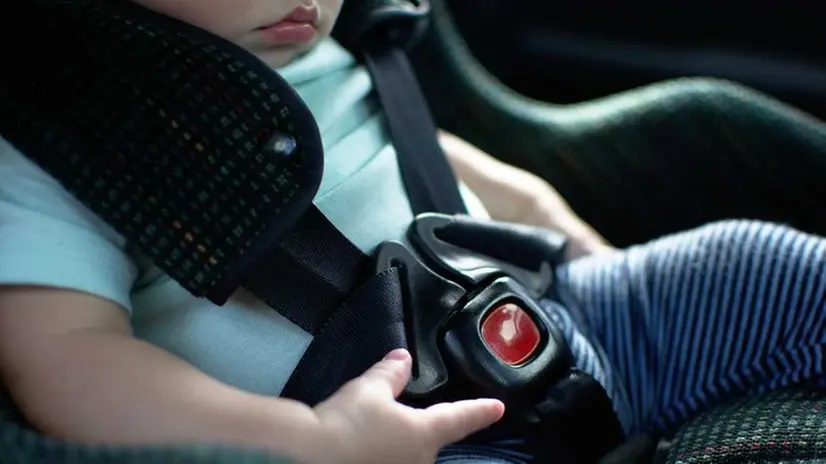 Un bambino in auto sul seggiolino